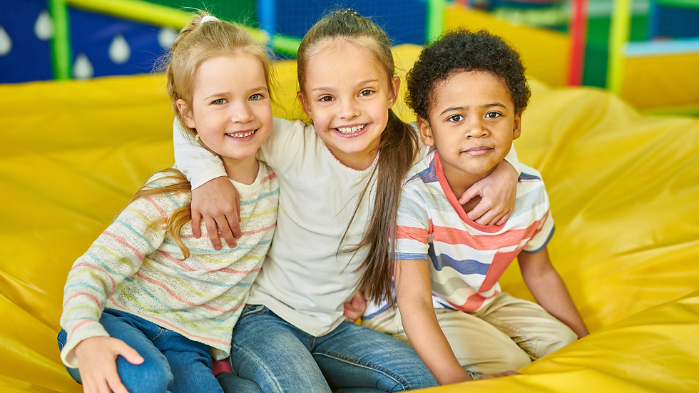 Group of smiling kids sitting together at Willits Kids Corner indoor playground in Willits, CA