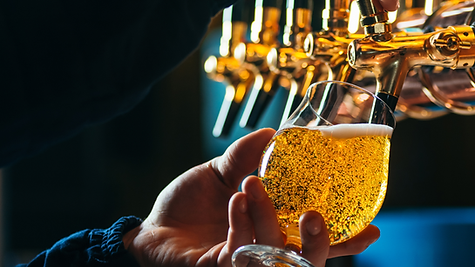 Bartender pouring fresh beer into a glass with a golden color.