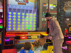dad and kids playing in the arcade at the fun lab