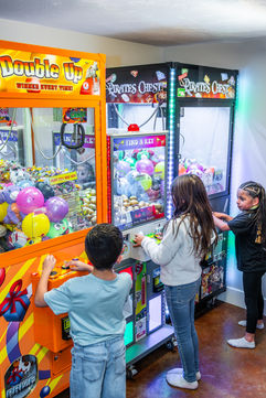 Kids playing a claw machine in the arcade at Bounce City Idaho Falls.