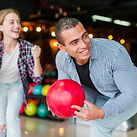 Man smiling while lining up a bowling shot
