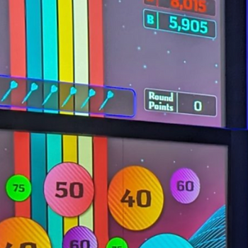 Colorful arcade game screen shows scores, points, and various colored bubbles. Level Up Bowl & Bistro Krazy Darts