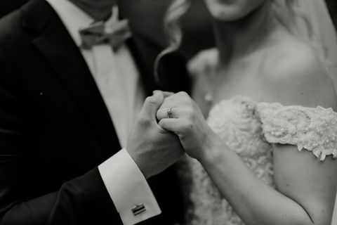 Black-and-White Photo of Couple Holding Hands at Wedding