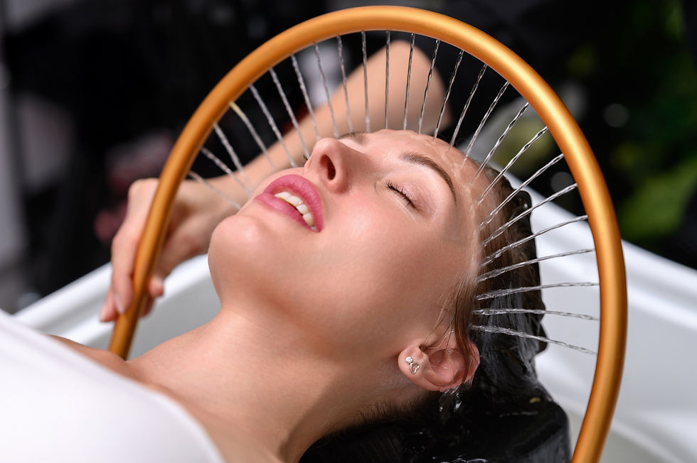 A woman enjoys a Japanese head spa session while water streams gently flow from a golden a