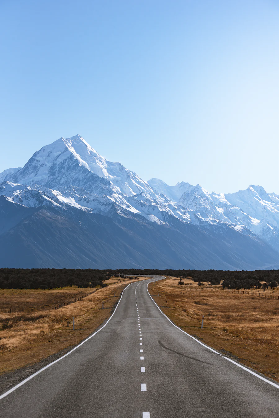 A lone highway leads to a mountain range on the South Island of rural New Zealand