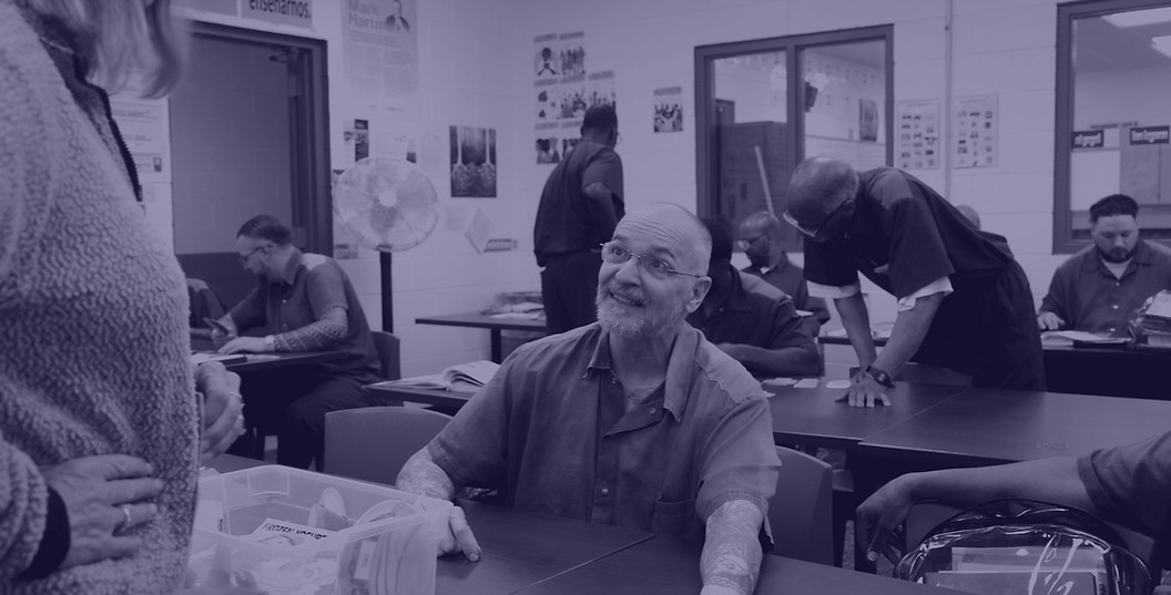 A student smiles at a teacher while sitting in a classroom