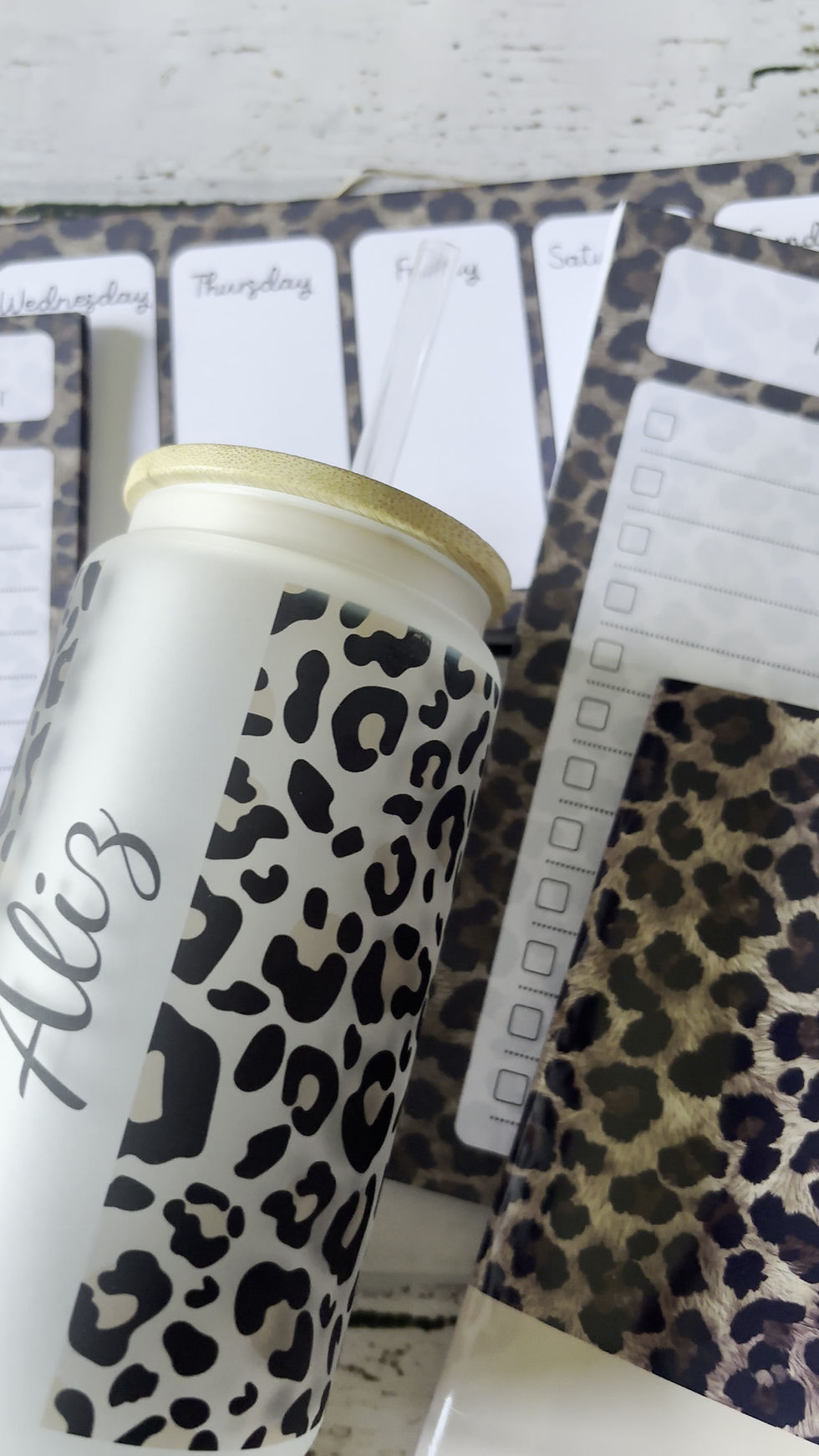 Thumbnail: Close-up of a personalised leopard print desk bundle featuring a custom frosted glass tumbler, a notebook, and various notepa