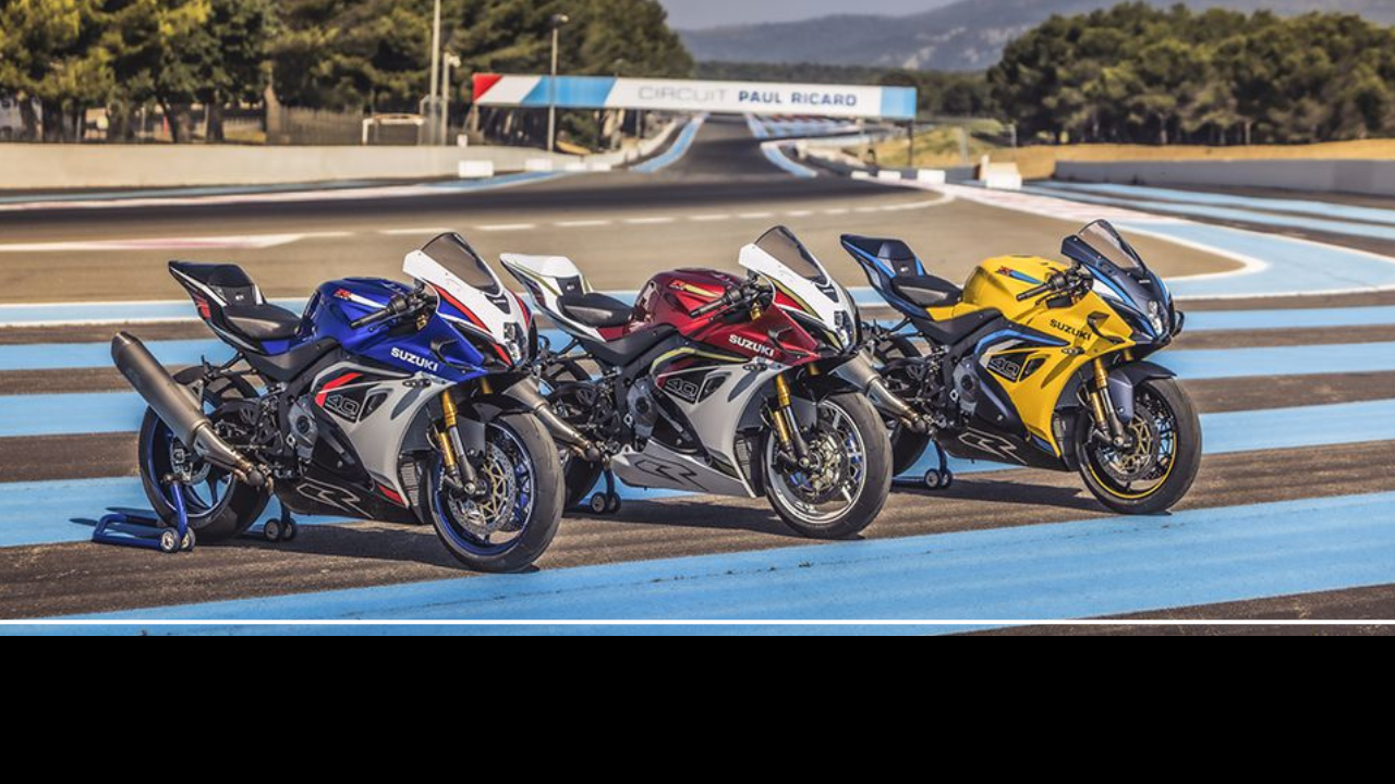 Trois motos Suzuki GSX-R1000R édition 40e anniversaire en bleu, rouge et jaune sur le circuit Paul Ricard au Castellet