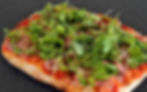 Pinsa Romana served on a wooden board, sliced and ready to share