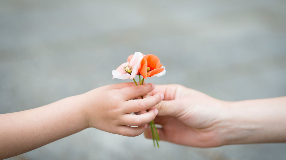 a small bouquet of wildflowers passed from a little hand to a bigger hand.