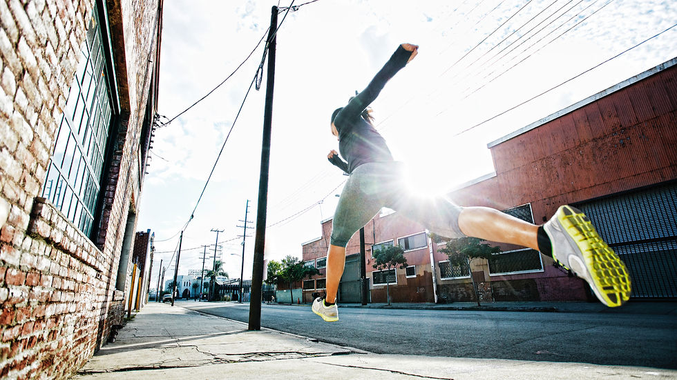 A runner running across old streets with the light breaking through in the back.