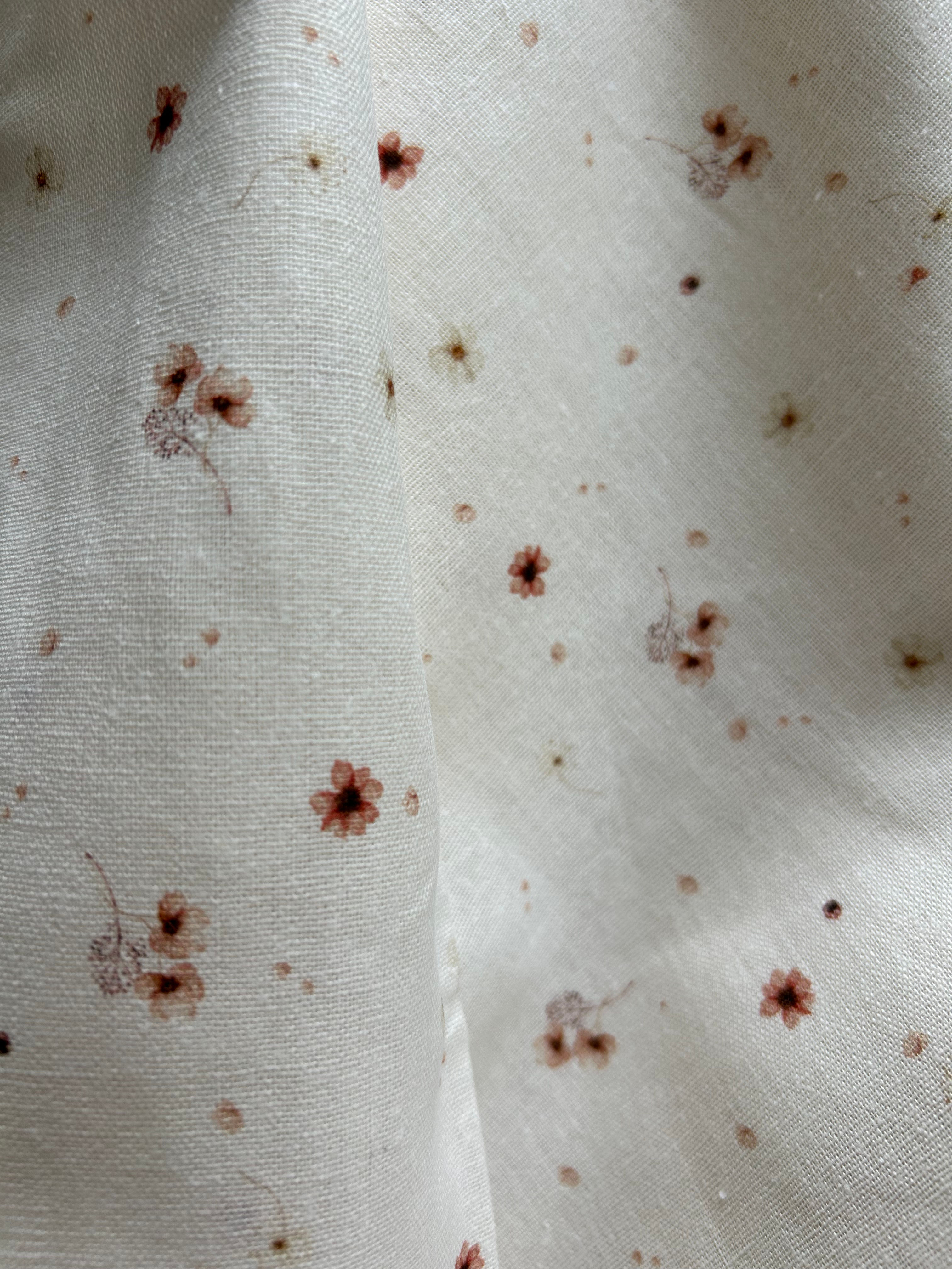 pink flowers and petals on linen blend fabric (sold by half y