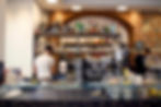 Caffetteria con mattoni a vista d'epoca, frontale specchiato ed effetto pietra. struttura metallica portabottiglie e porta bicchieri