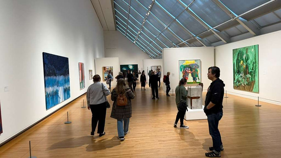Visitors observe modern artworks in a spacious contemporary gallery