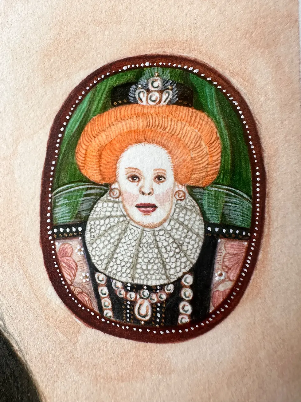 Thumbnail: Detailed view of the miniature oval paintings, including a cat dressed in royal attire as a brooch and Queen Elizabeth I