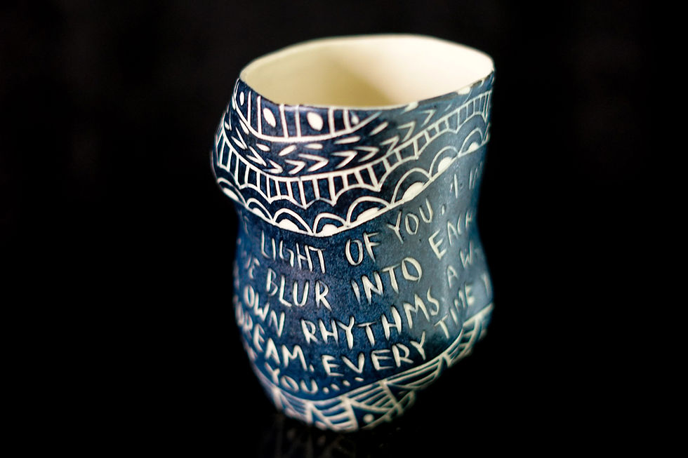 Thumbnail: Close-up of sgraffito ceramic engraving highlighting wave motifs, geometric triangles, and crisp white script text.