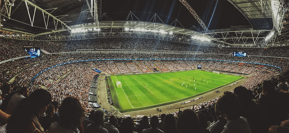 A stadium filled with passionate fans leaning over, chanting, and waving scarves to the rhythm of upbeat soccer songs
