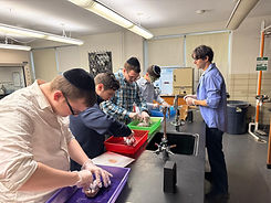 Students wearing yarmulkes conducting a science experiment