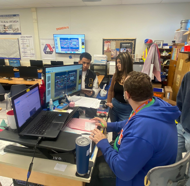 Students and yearbook adviser working on edits to the yearbook