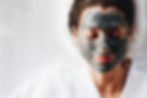 Woman relaxing with a charcoal facial ma