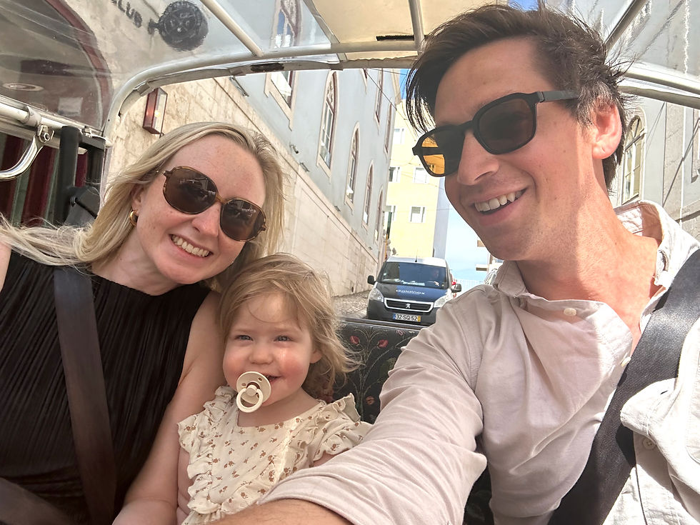 Man, woman and young girl riding through city street in a tuk tuk