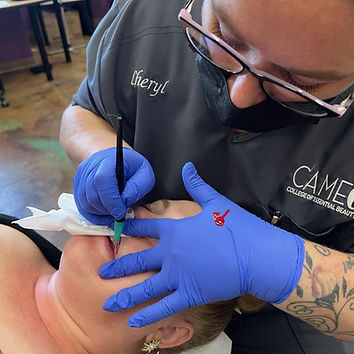 Permanent makeup artist applying pigment to a clients lips.