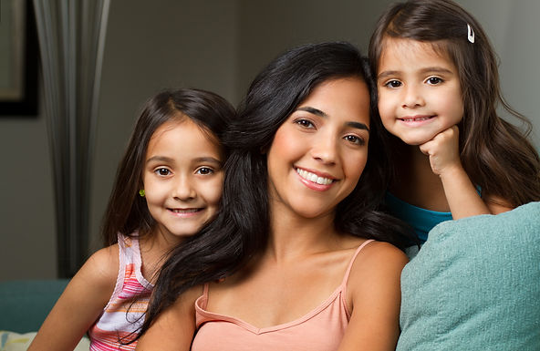 Mother sitting on couch with two young girls