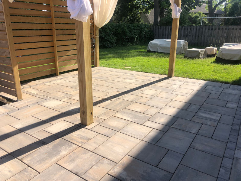 A floor patio with a mix style  correlating with the wooden fence and post.