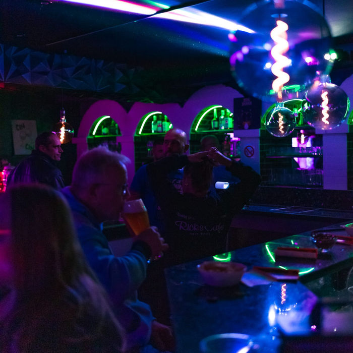 Gäste an einer Bar mit Neonbeleuchtung