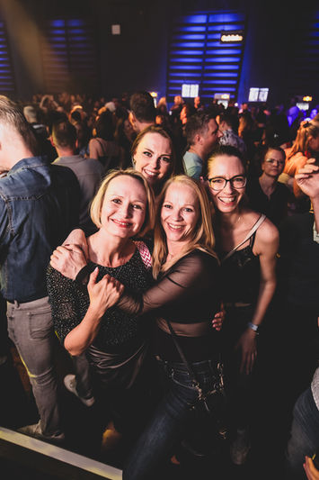 Vier Frauen lächeln im Publikum