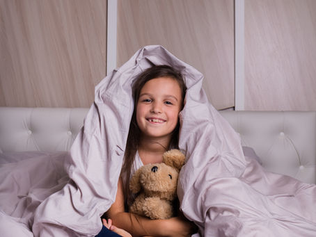 little girl under bed covers