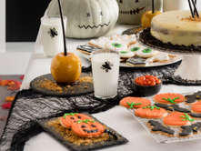 fall table setting with halloween cookies and cakes