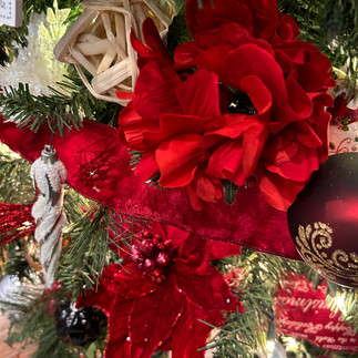 Red hydrangea floral pick on a Christmas tree and a glass icicle and red ball ornament Christmas tree decorating