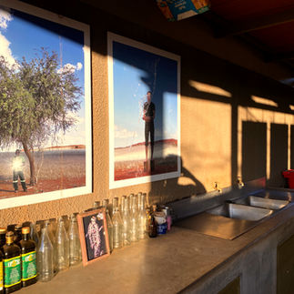 Artwork displayed inside the Wolwedans recycling facilities above a workbench with recycled glass bottles and sorting areas.