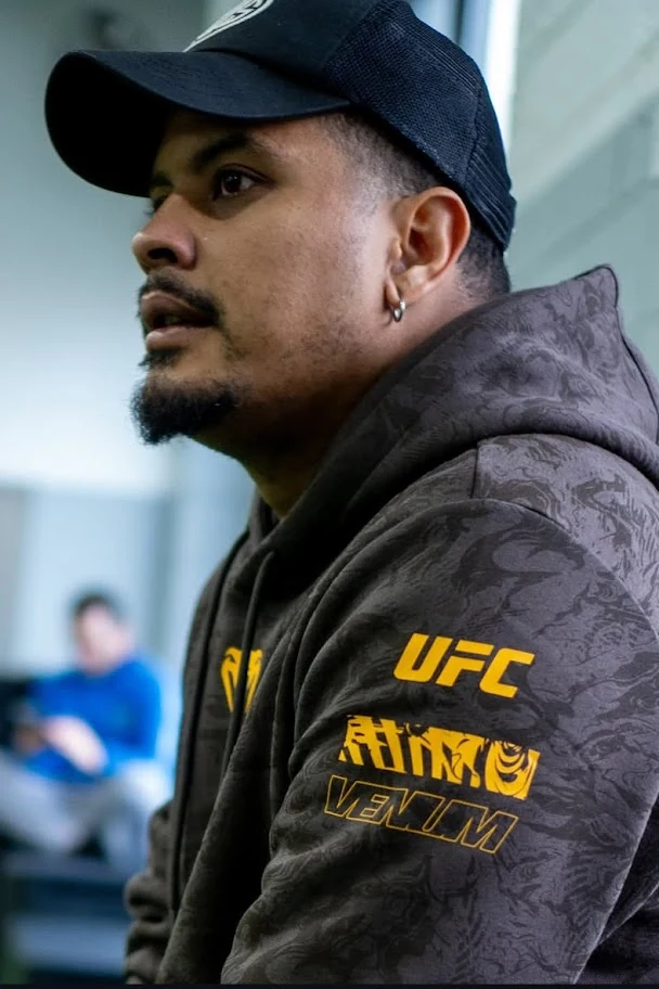 Fellipe Lima in a black cap, watching training attentively.