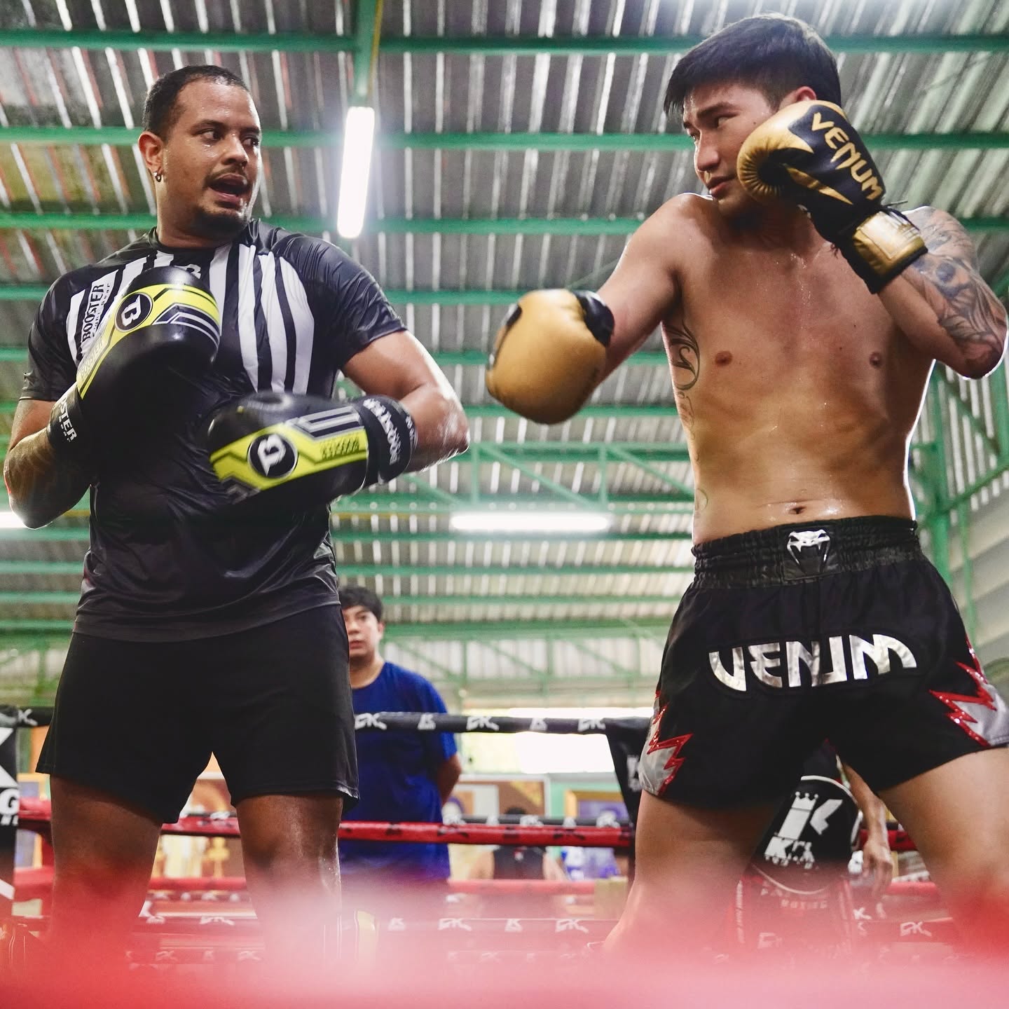 Fellipe Lima coaching Tawanchai during pad training.