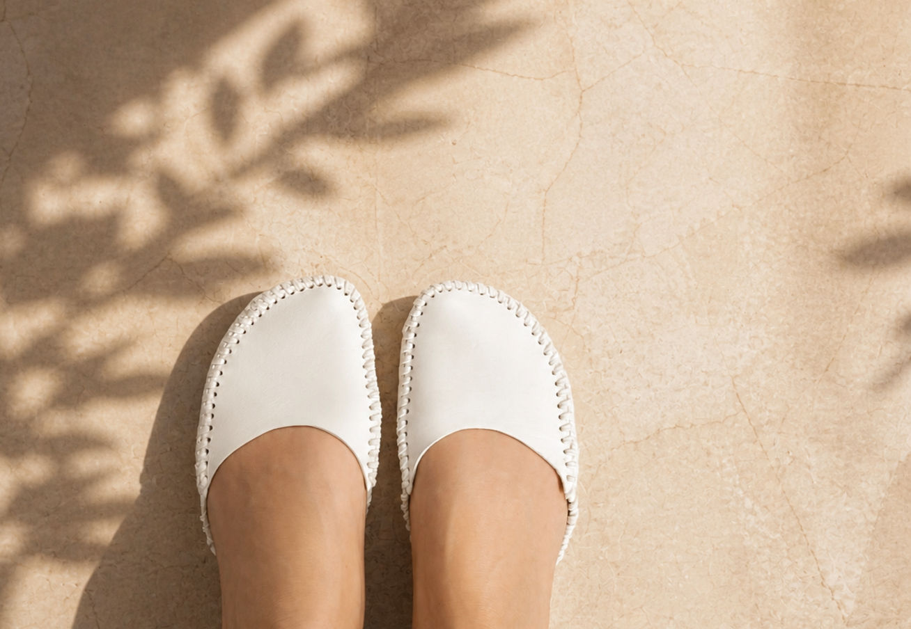 White leather Essential Slip-Ons worn on foot, viewed from above.