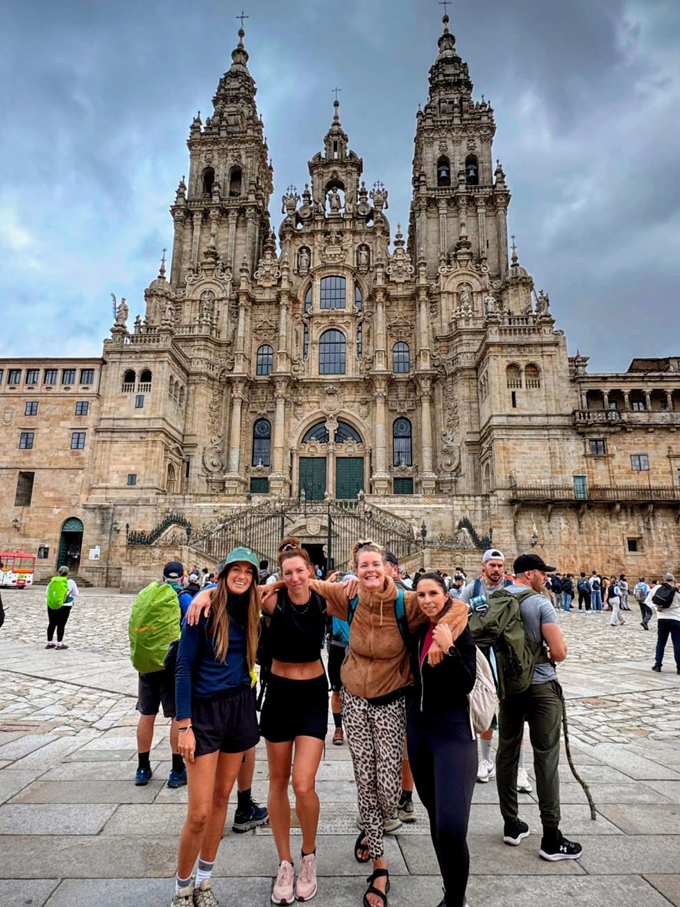 Vier dames bij het eindpunt van de camino in Santiago de Compostela.