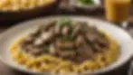 Close-up view of a bowl of beef stroganoff served over egg noodles