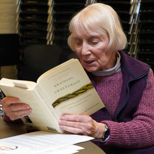 Woman reading "Braiding Sweetgrass" book