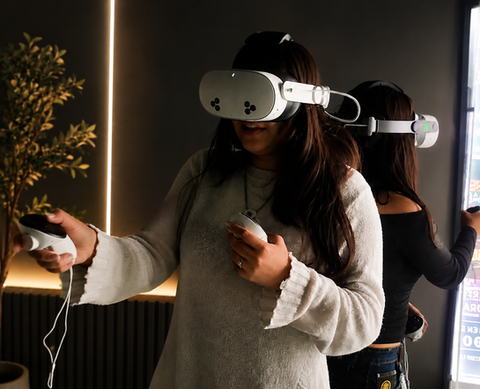 studiantes participando en un taller educativo interactivo utilizando visores de realidad virtual modernos y mandos inalámbricos en interiores.