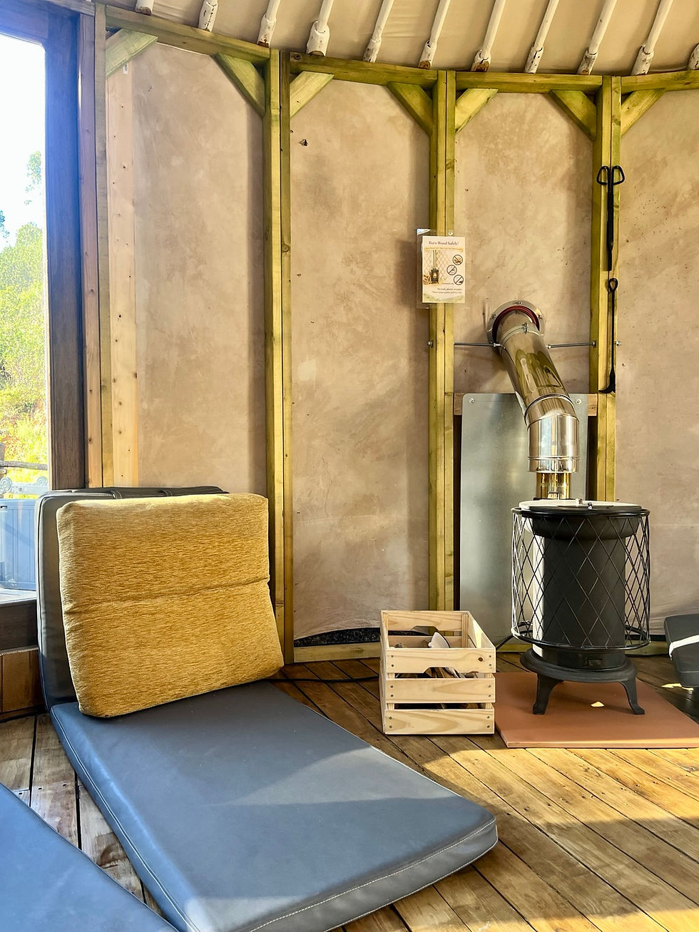 Interior of the main gathering yurt prepared for group session with mats, natural light, and calm atmosphere