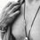Thumbnail: Male model wearing THYRA silver hagstone pendant close-up, layered with bracelets and linen.