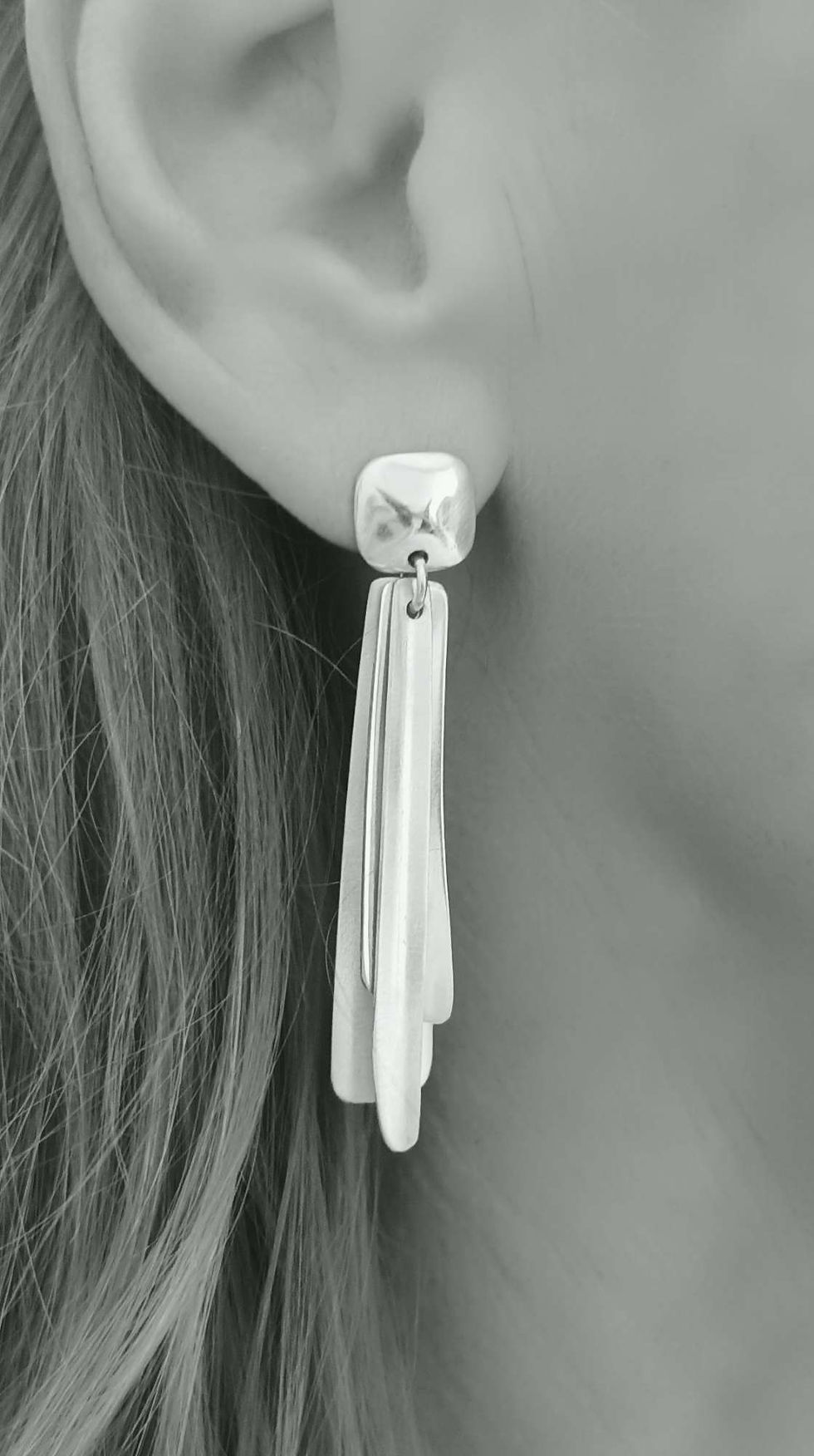 Thumbnail: Model wearing CASCADE sculptural silver earrings, highlighting theirr fluid movement and elegant design.