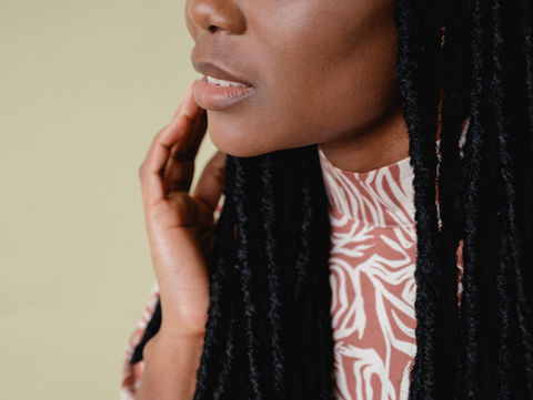 black woman with locs touching her face