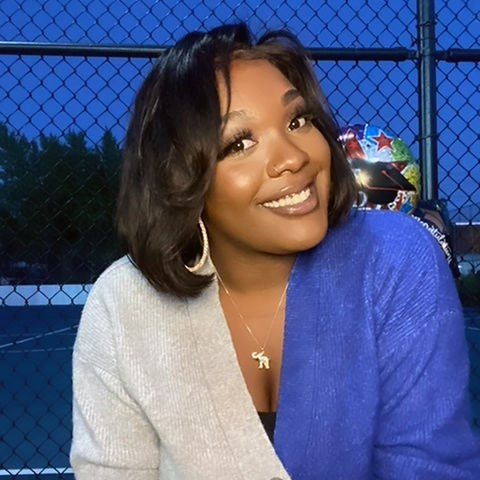 beautiful black woman wearing a gray and blue sweater