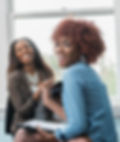 two black women smiling in an office