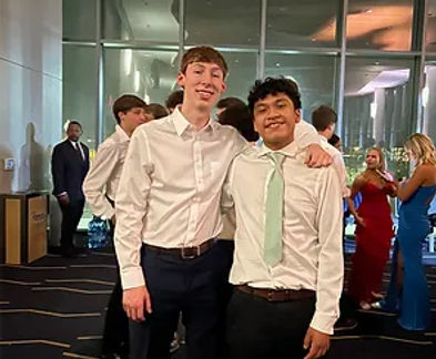 Two friends posed for a picture dressed in formal attire.