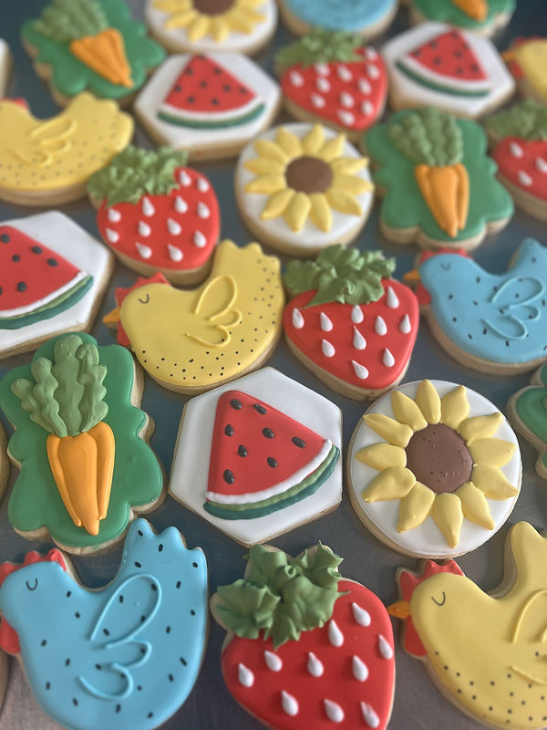 Decorated cookies shaped like sunflowers, fruits, and chicks
