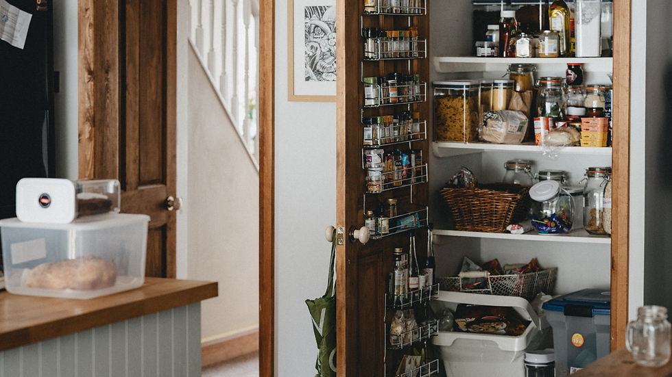 an open door revealing a kitchen pantry stocked with jars of food and spices